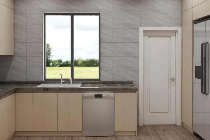 Sink run under a window with light oak lower cabinets, brown granite counters, a stainless dishwasher and a white interior door