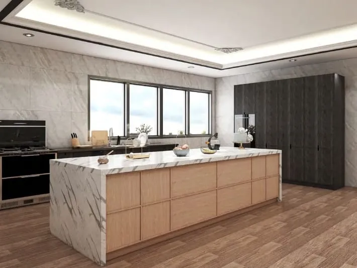Kitchen with a white stone waterfall island, a dark wood tall cabinet wall and a cove-lit ceiling