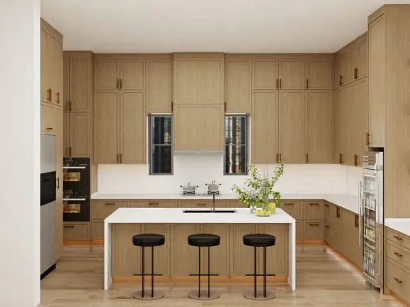 U-shaped white oak kitchen with an island seating three on black stools and wall ovens on the left