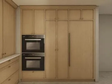 Tall oak run with stacked wall ovens beside a panel-ready refrigerator with long pulls