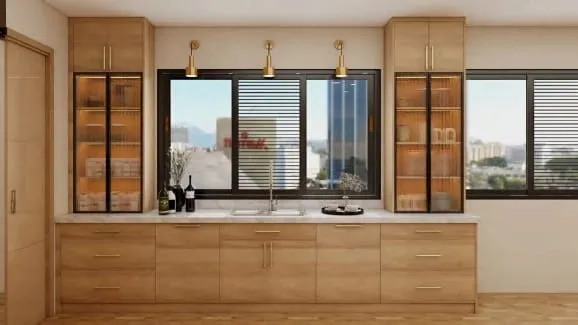 Sink under a wide window with three brass sconces between ribbed-glass oak cabinets