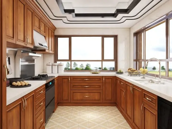 Corner sink under two windows in a cherry kitchen with a layered ceiling and dark trim
