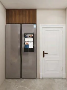 Stainless refrigerator in a wall niche with a walnut cabinet above, beside a white panel door