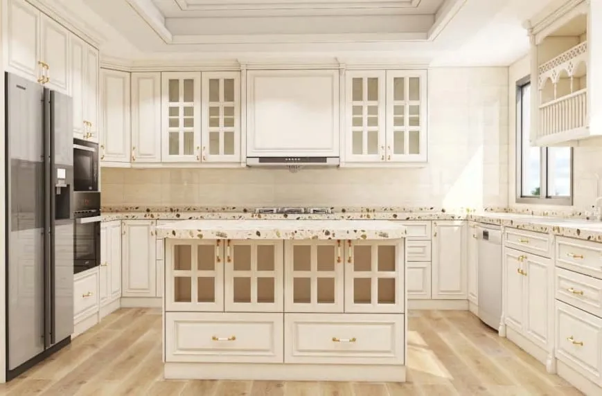 Cream traditional kitchen with glass-front cabinets, a terrazzo-style island and a stainless refrigerator