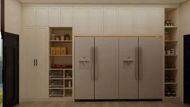Two side-by-side stainless refrigerators flanked by open pantry shelves in cream cabinetry