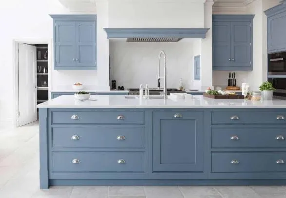 Blue island with cup pulls and a professional faucet in front of a blue hood surround