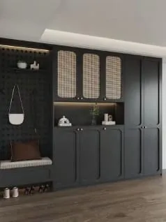 Charcoal drop-zone cabinetry with cane door inserts, a black pegboard and a cushioned bench over shoe cubbies