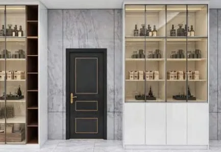Black door with gold trim between gray marble walls and lit glass display cabinets