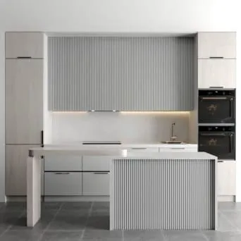 White kitchen with pale gray reeded upper panels, a reeded island end and two black wall ovens