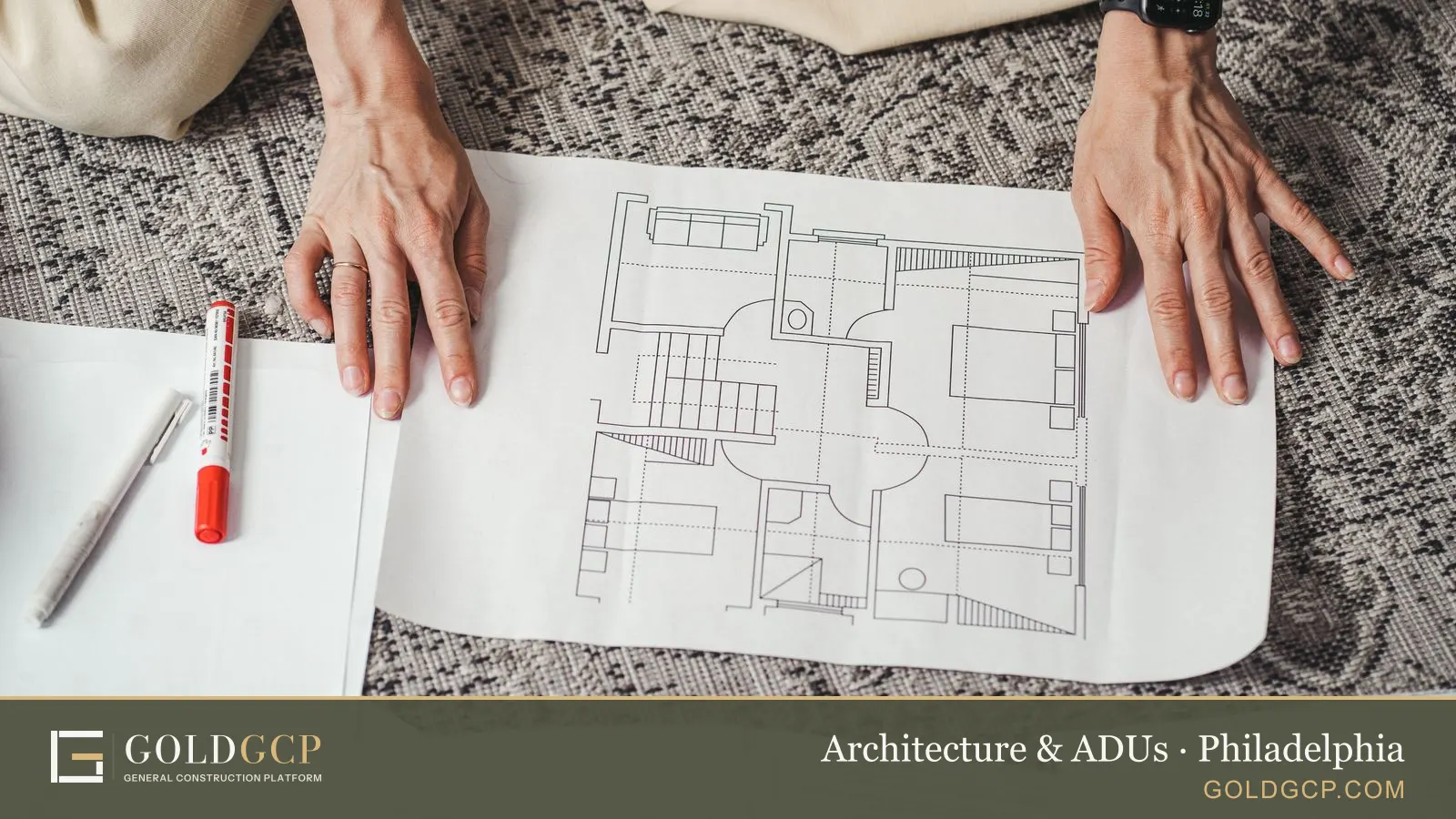 Hands on a detailed architectural floor plan paper showing a home design layout.