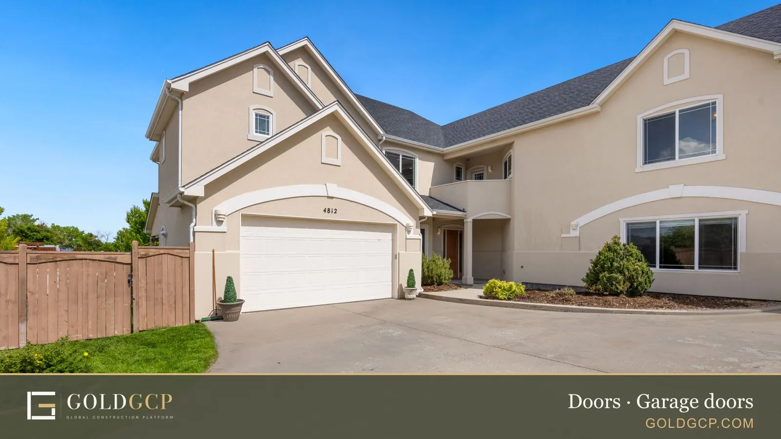 A suburban home with a double garage door and a landscaped front yard