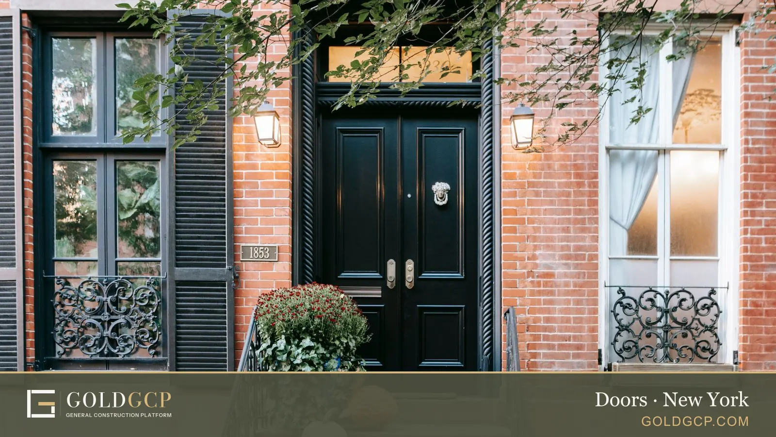A black double entry door at the top of a brownstone stoop in New York