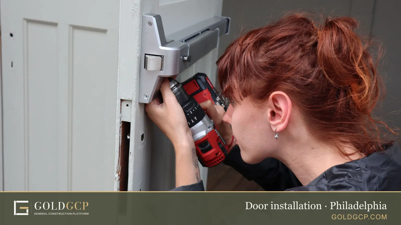 Caucasian woman focusing on door installation with a power drill, side view.