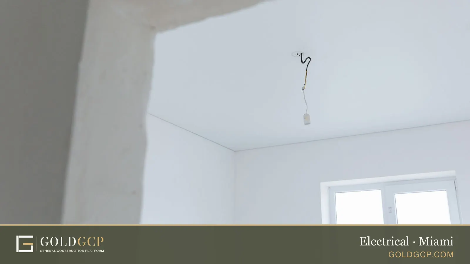 A renovated room with a light fixture wire hanging from the ceiling
