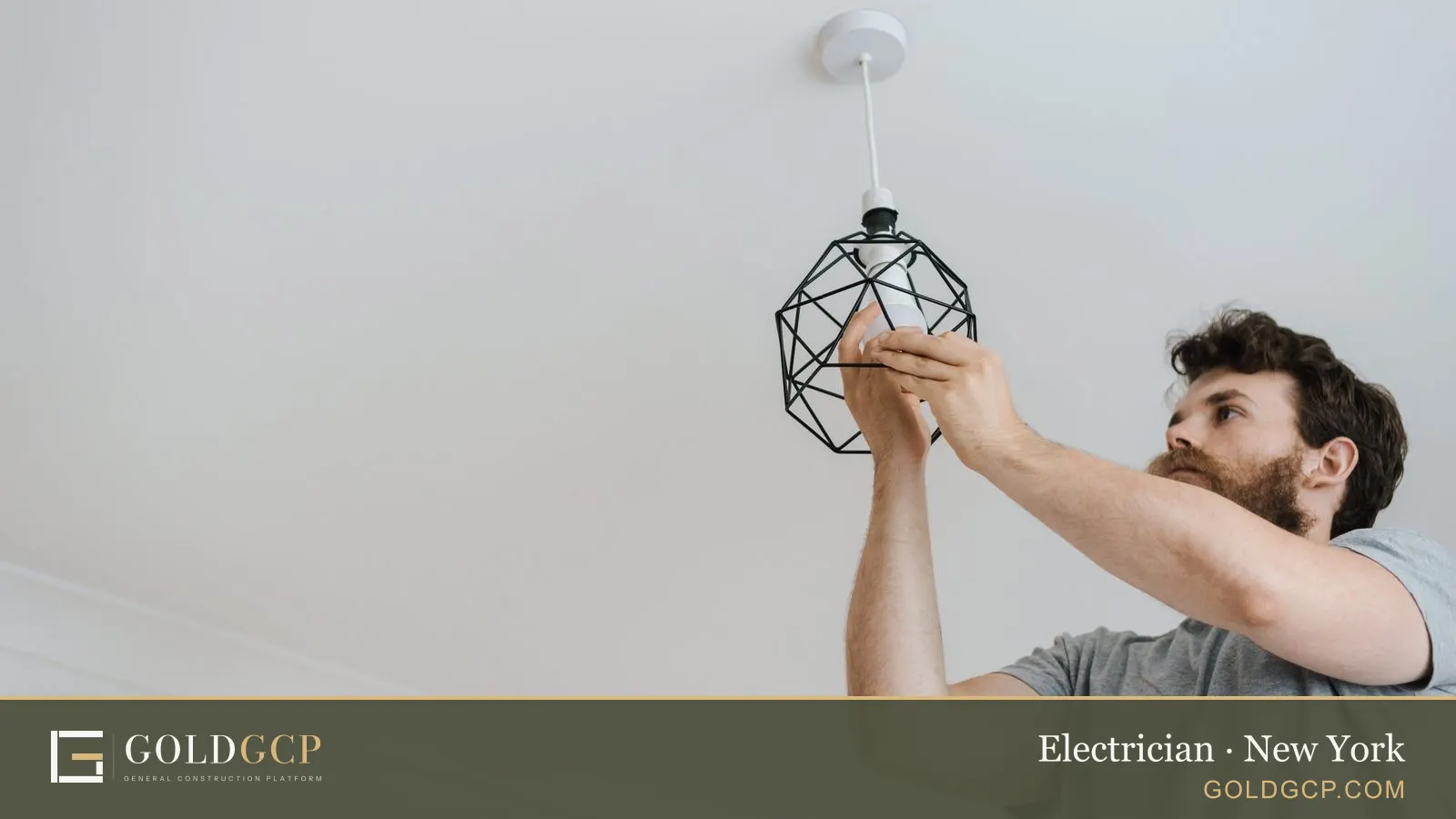 An electrician fitting a light fixture during an apartment renovation