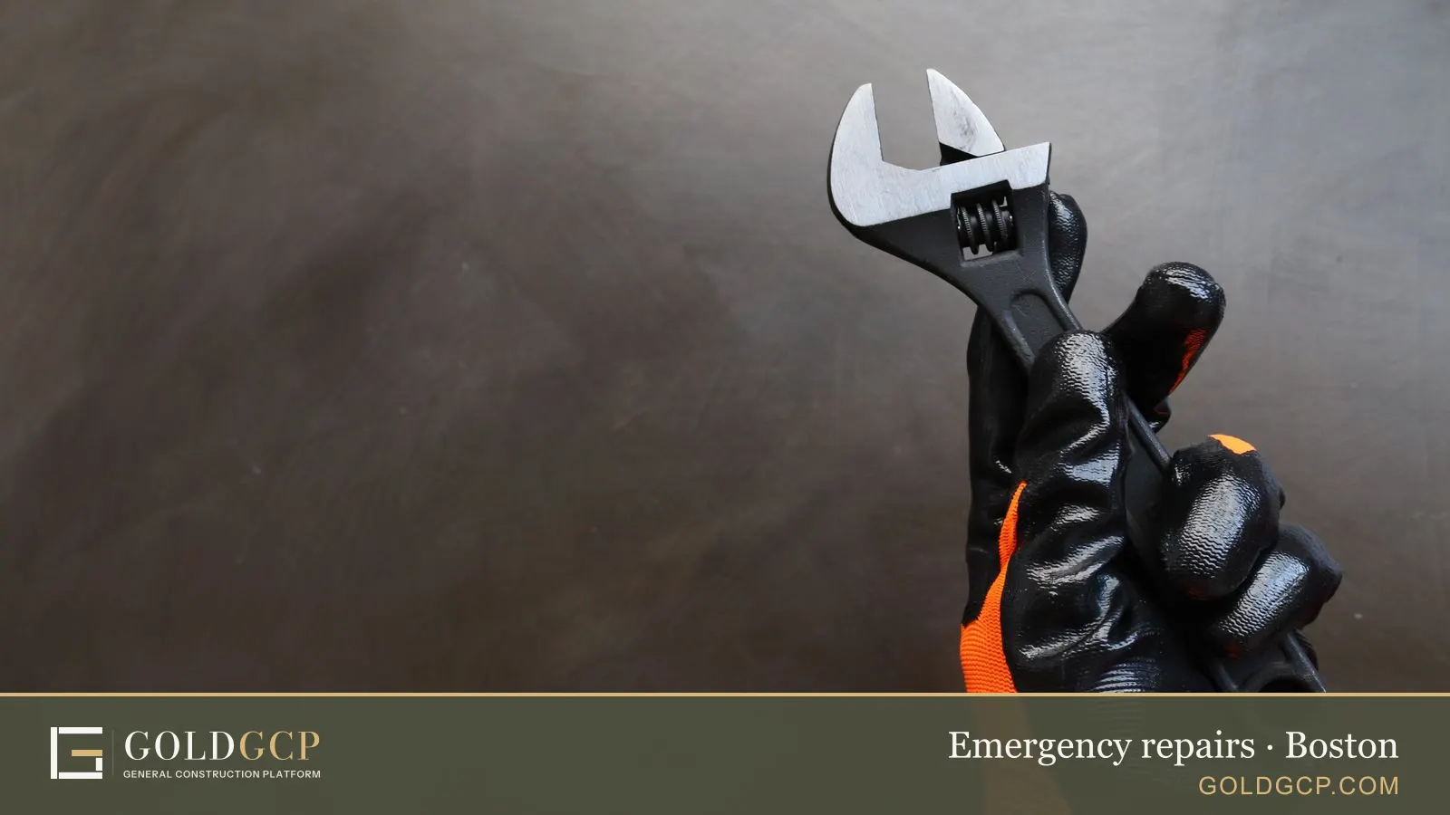 A gloved hand holding an adjustable wrench on a dark background.