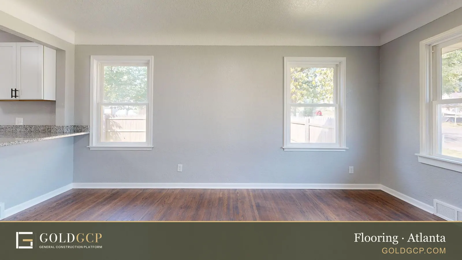 Spacious empty room with hardwood floors and natural light.