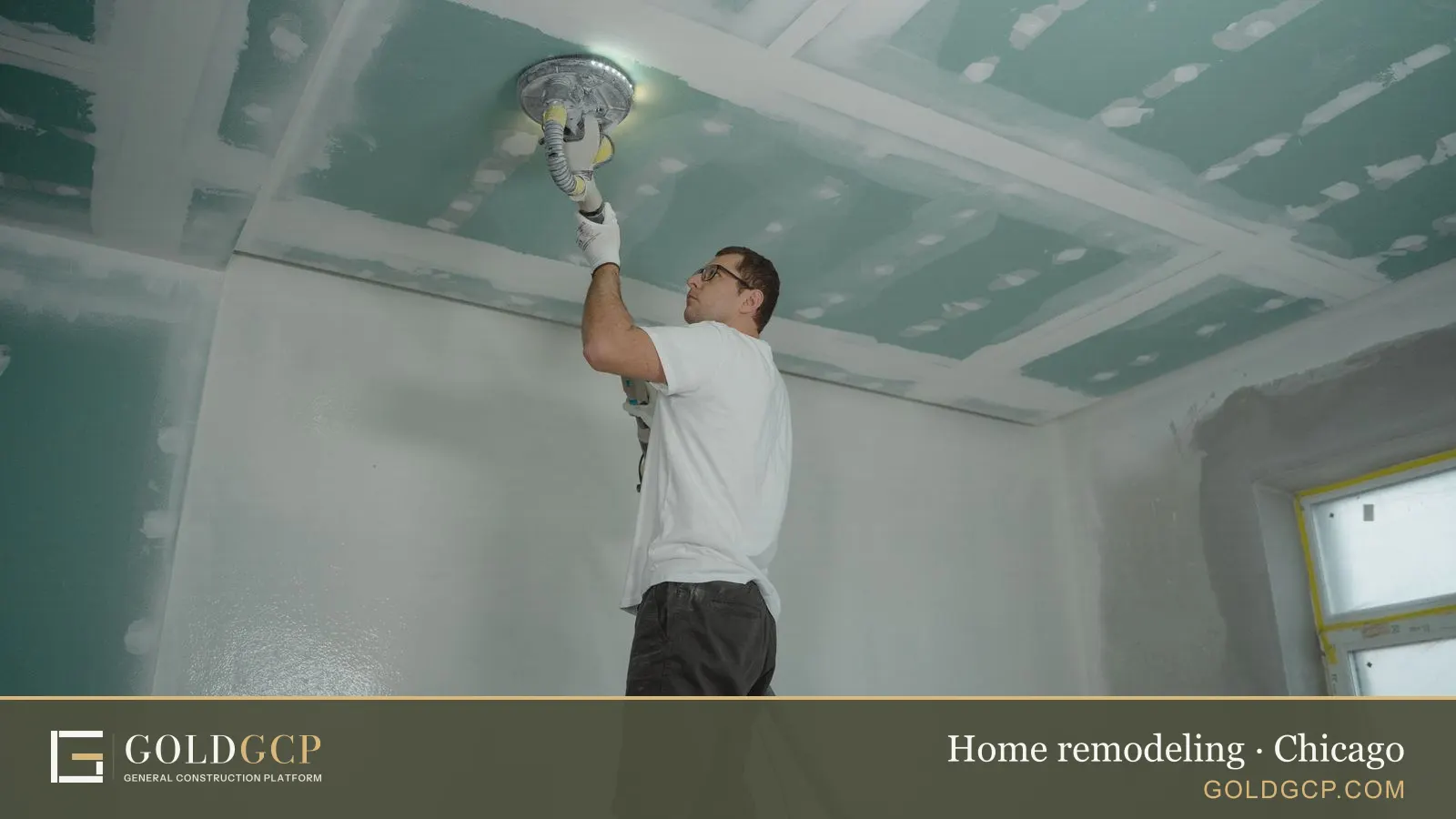 A worker polishes a ceiling indoors during a home renovation.