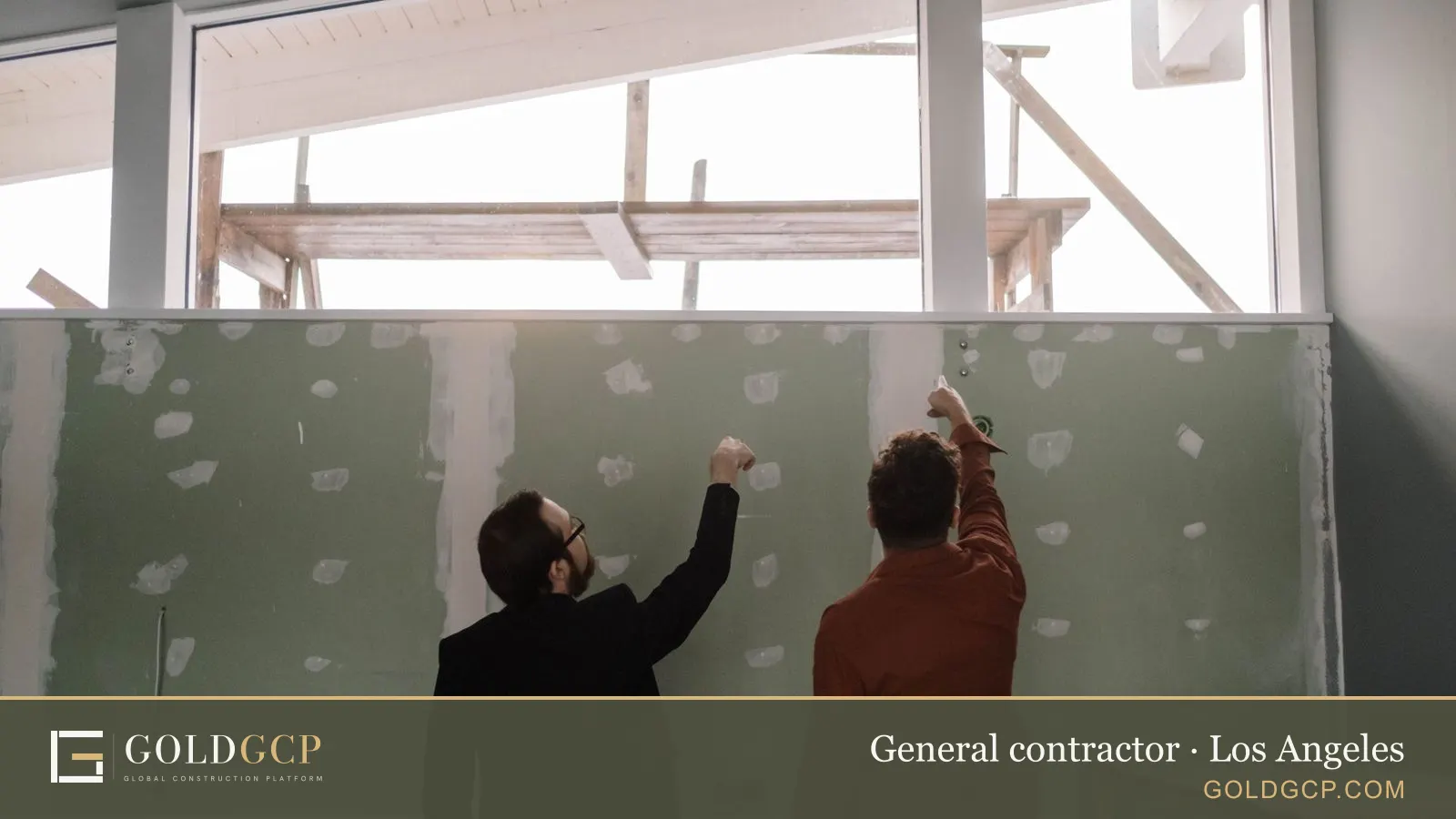 Two men discussing an interior wall during a home renovation