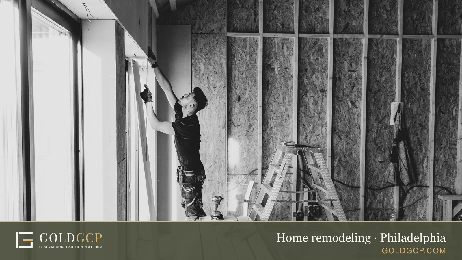 Black and white photo of a worker installing drywall indoors.
