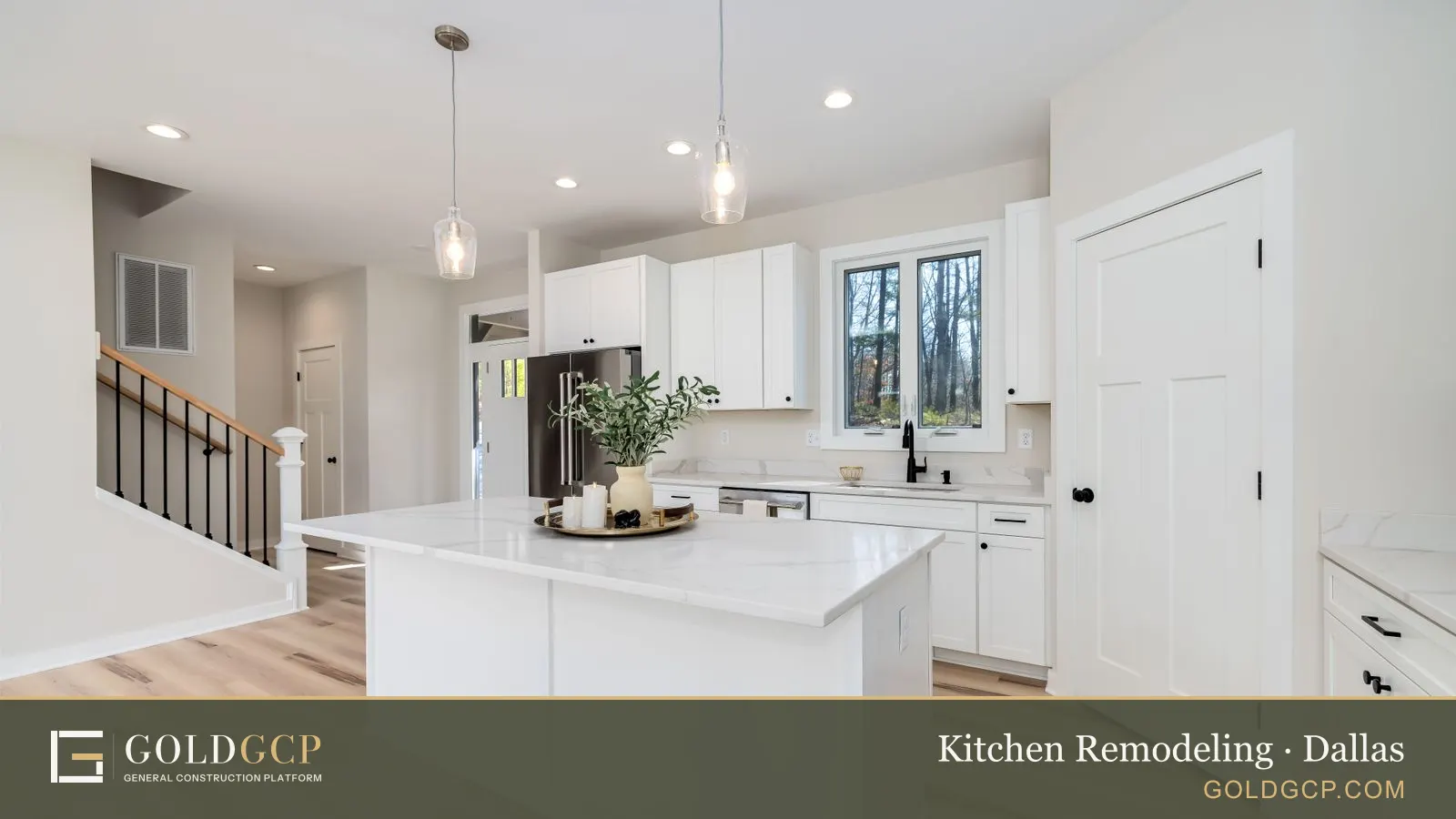 A white kitchen with shaker cabinets, a quartz island and pendant lights