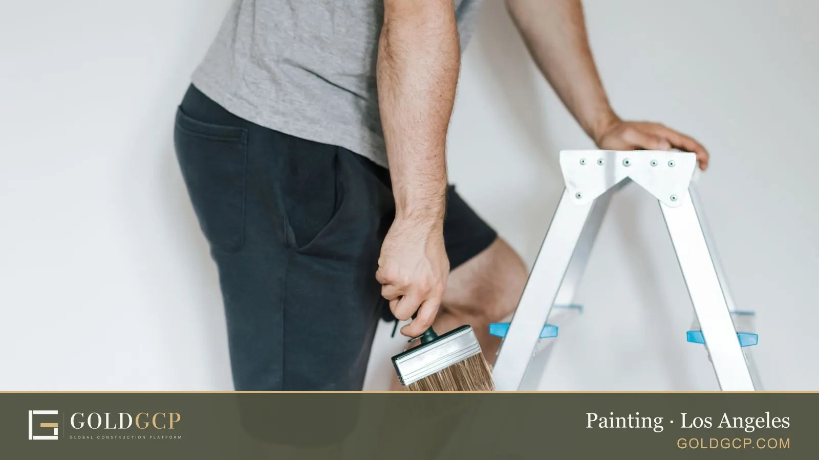 A painter on a stepladder getting ready to paint a light room