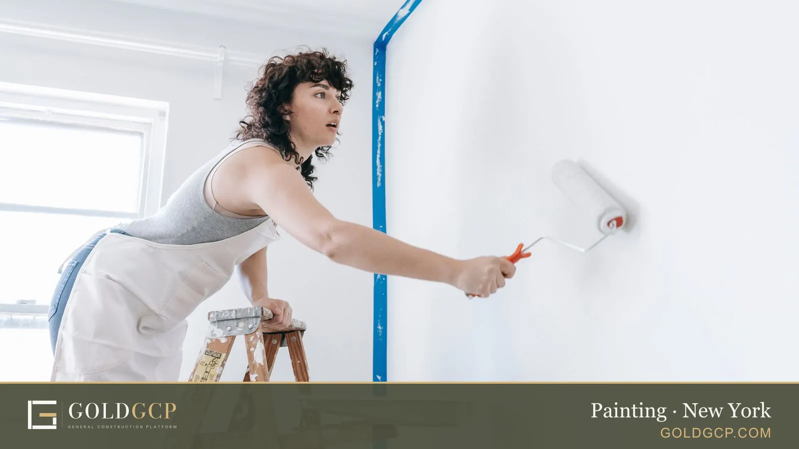 A person on a ladder painting an apartment wall white