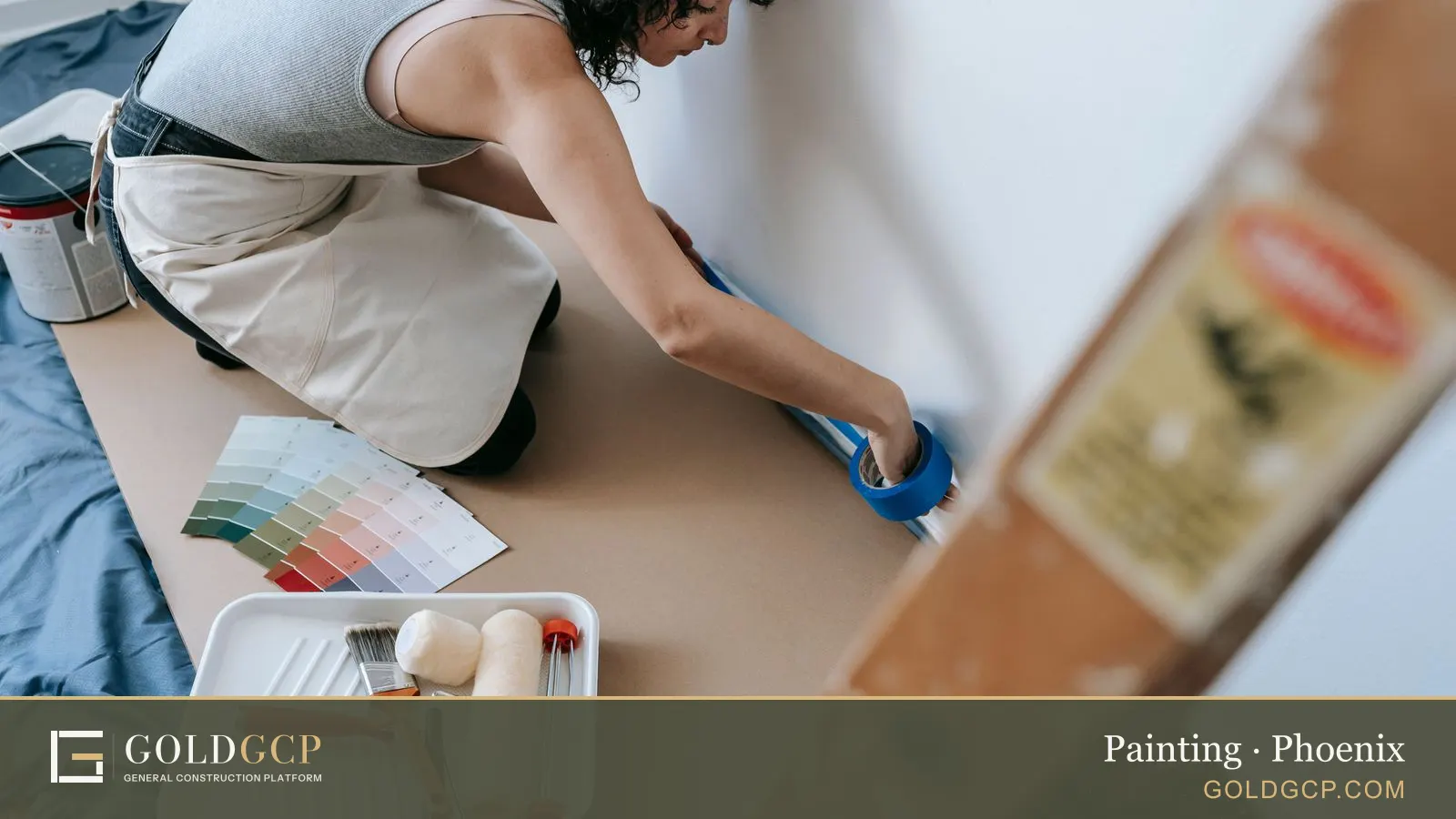 Woman using blue painter's tape for a home painting project in a modern apartment.
