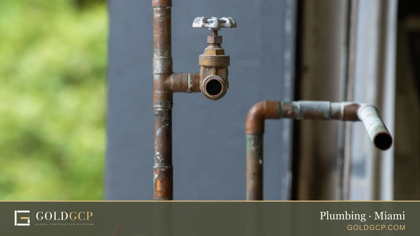 An old, rusted water pipe and valve on a wall