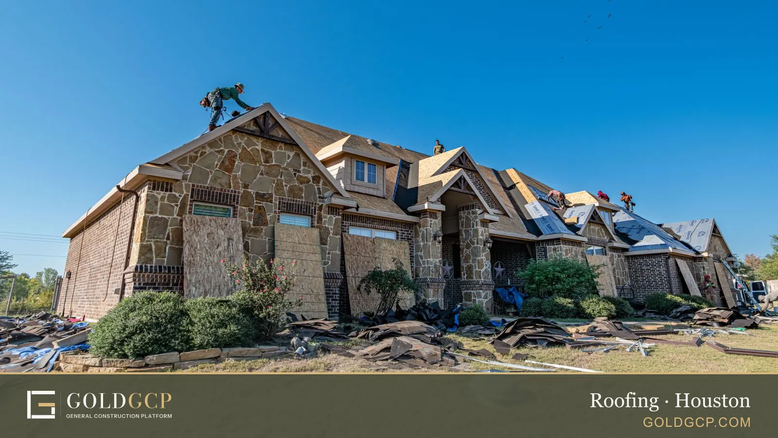 Roofers tearing off and replacing the roof of a brick and stone Texas home
