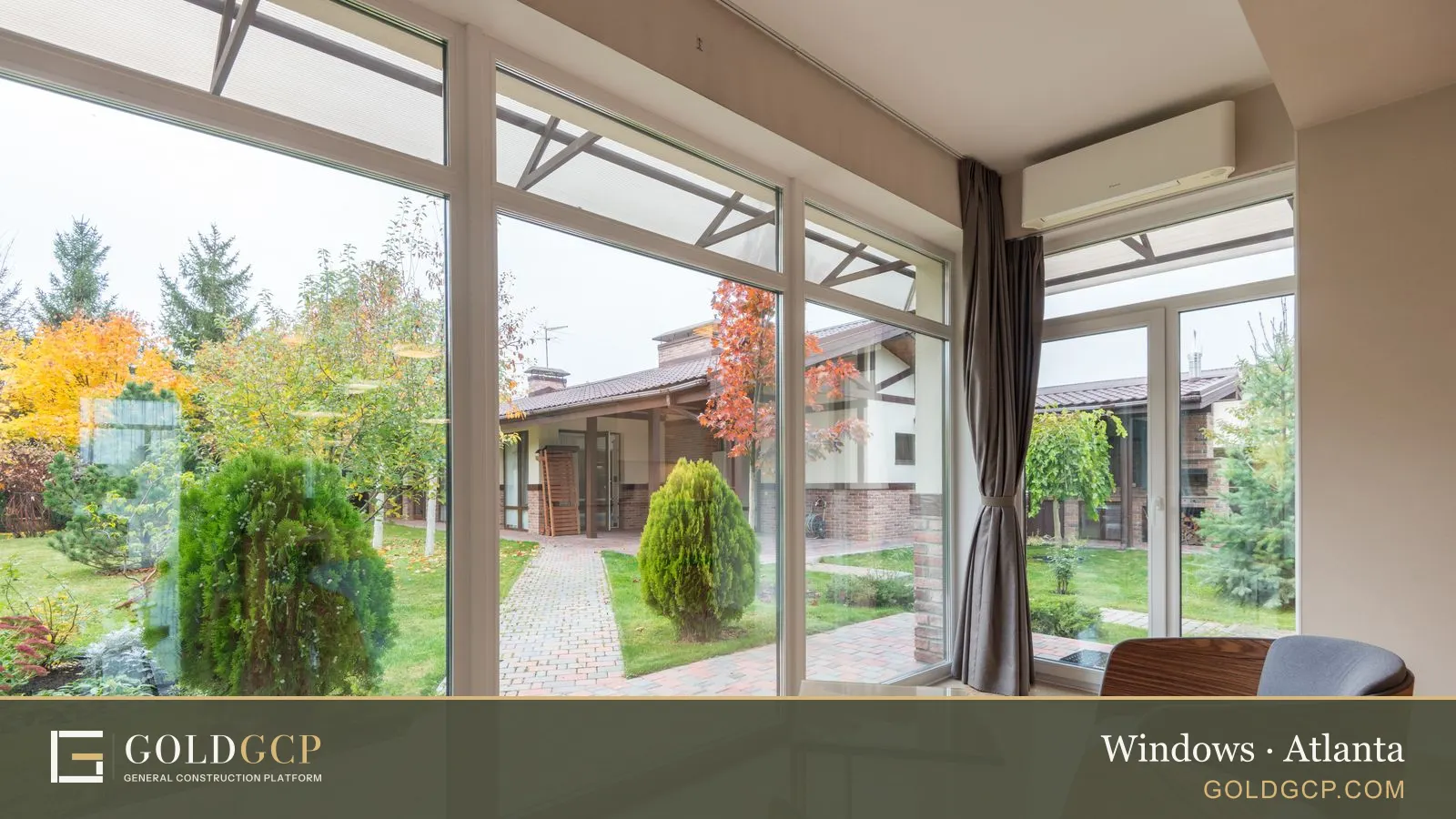 A bright room with large white-framed windows looking out on a garden