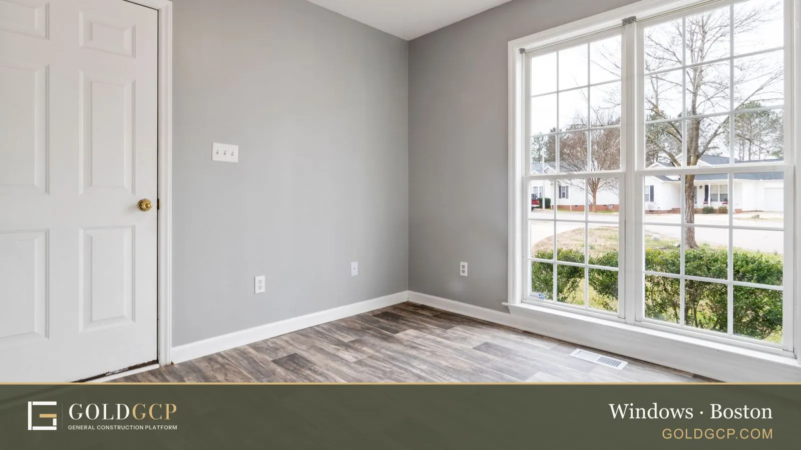 Empty room with wood-look flooring and a large double-hung window letting in daylight.