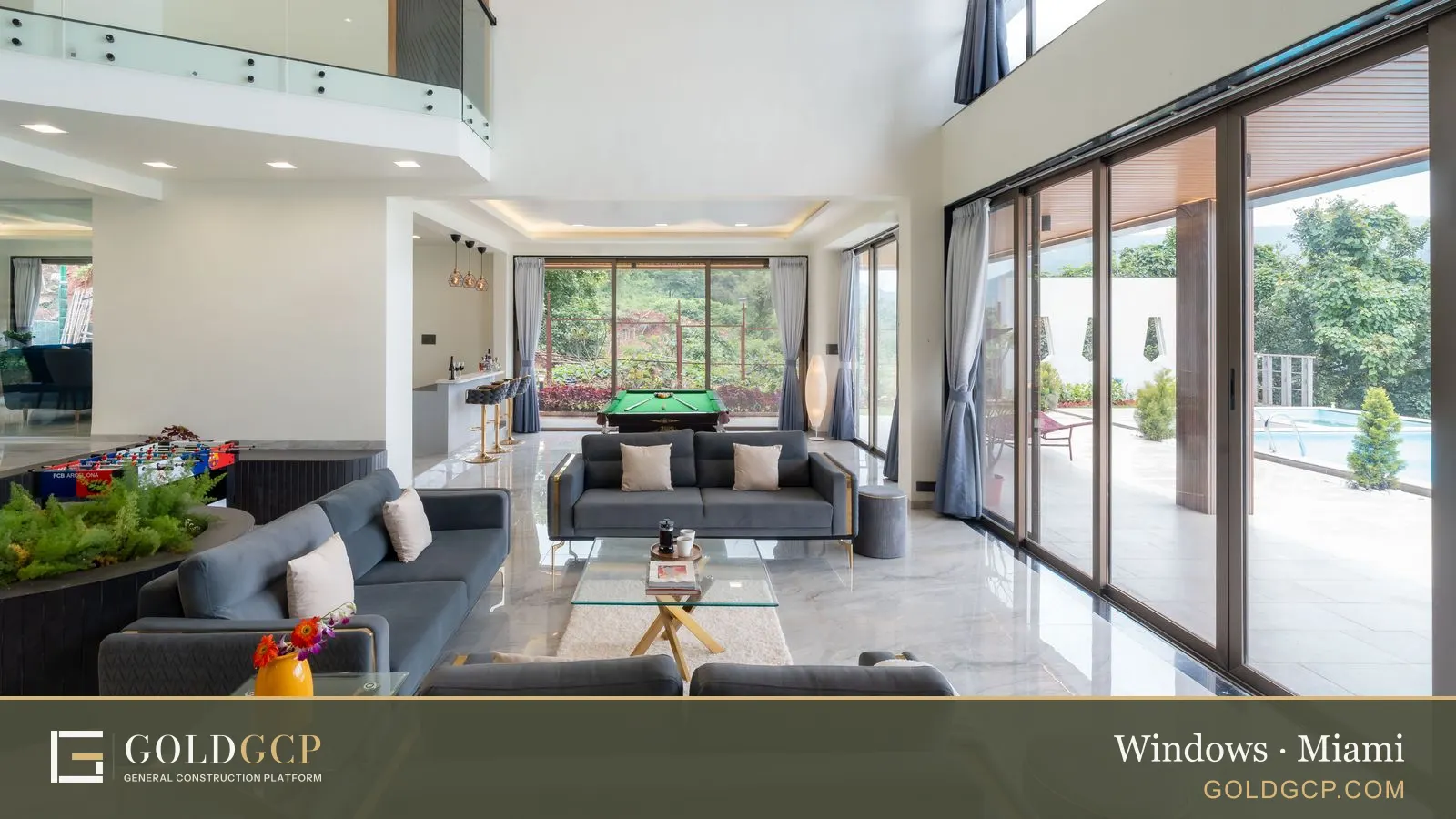 A living room with tall glass walls opening onto a pool and garden